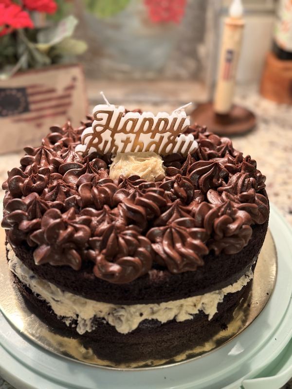 Chocolate layer cake with cookie-dough filling, chocolate rosettes and a Happy Birthday topper
