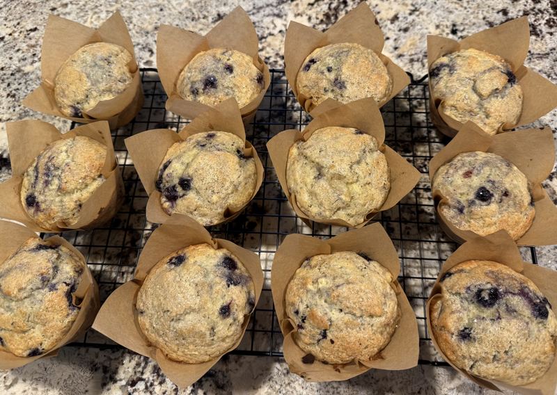 Blueberry muffins in brown tulip liners on a cooling rack