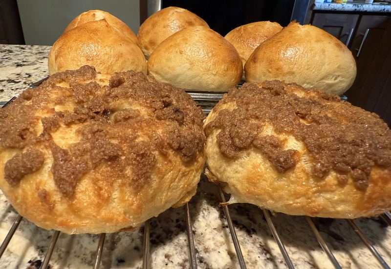 Cinnamon crumb-topped bread rounds with soft rolls behind