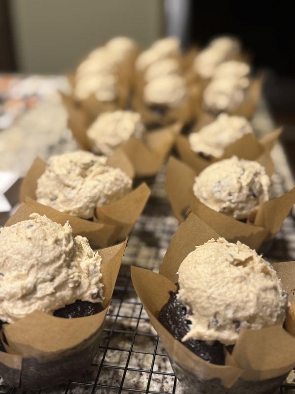 Chocolate cupcakes in tulip liners topped with cookie-dough frosting
