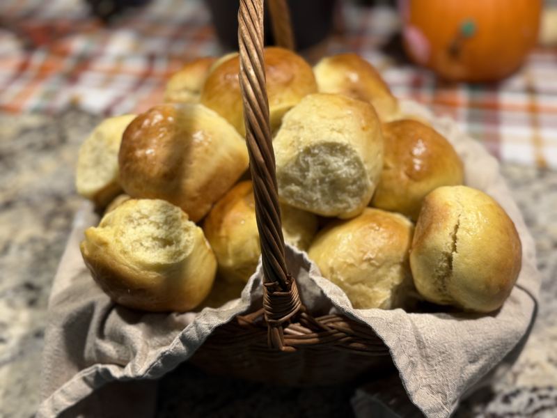 A basket of soft golden dinner rolls