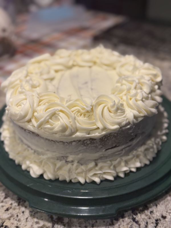 Layer cake topped with a ring of buttercream rosettes